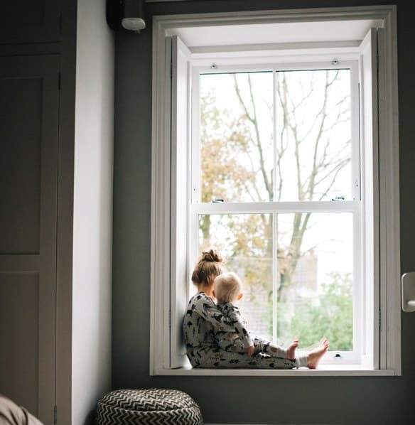 A plain-glass sliding sash window with a single clear pane in each sash and a view of trees